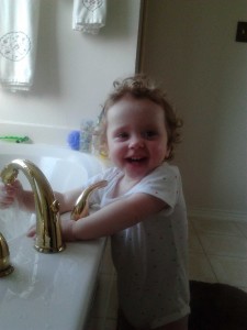 Standing by the tub and playing with the water
